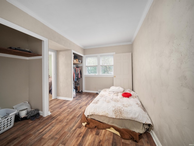 bedroom with a closet, crown molding, and dark hardwood / wood-style flooring