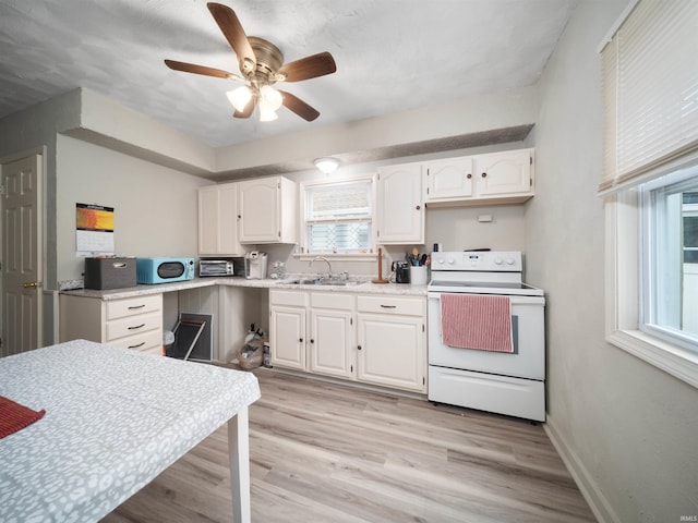 kitchen featuring ceiling fan, sink, range, white cabinetry, and light wood-type flooring