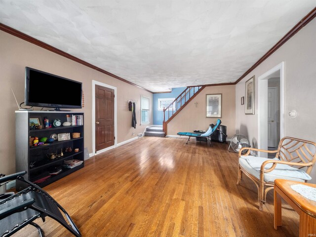 living area featuring ornamental molding and light hardwood / wood-style floors