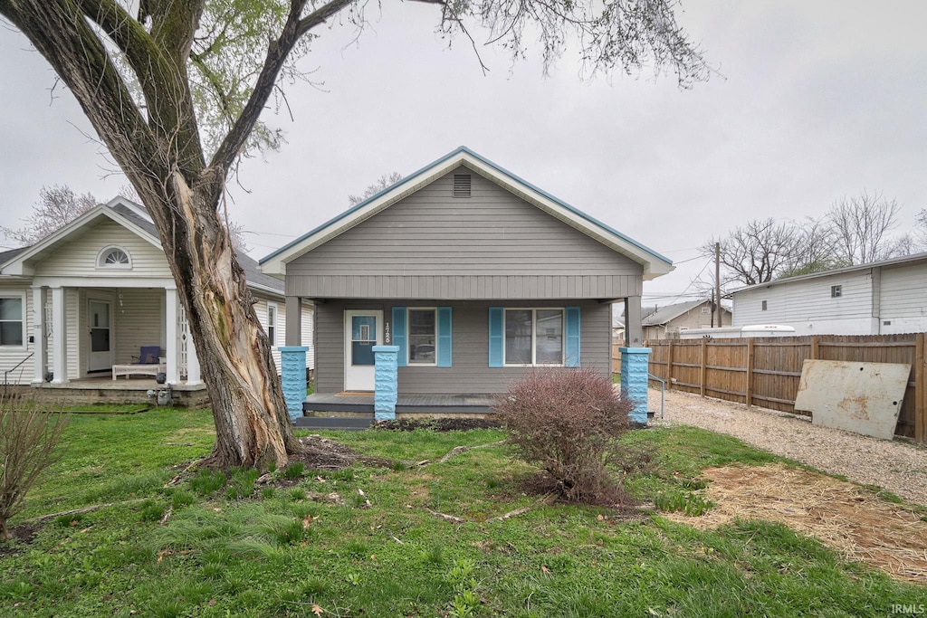 bungalow-style house with a front yard and covered porch