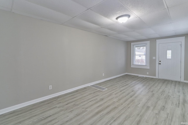 interior space featuring a drop ceiling and light wood-type flooring