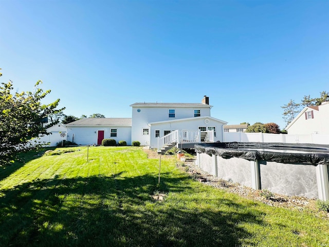 back of house featuring a covered pool and a yard