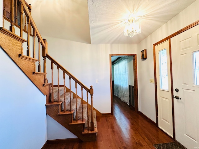 foyer with an inviting chandelier and dark hardwood / wood-style flooring