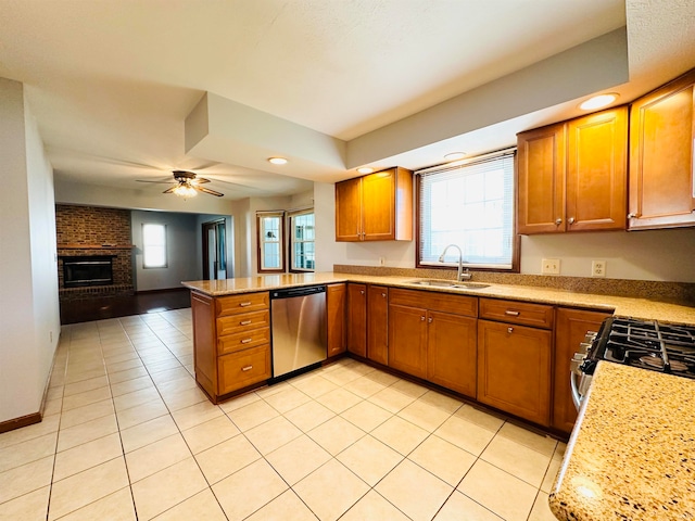 kitchen with light tile patterned flooring, sink, kitchen peninsula, appliances with stainless steel finishes, and ceiling fan