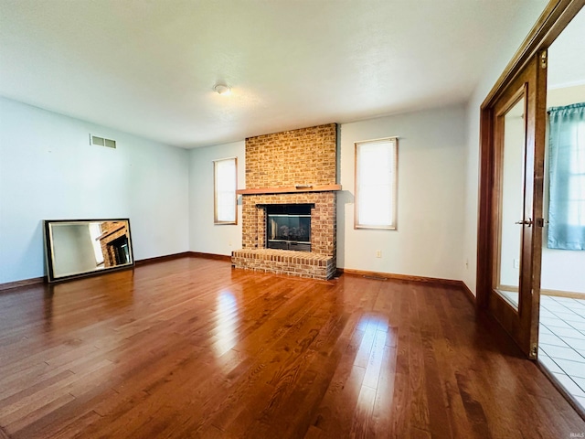 unfurnished living room featuring wood-type flooring and a fireplace