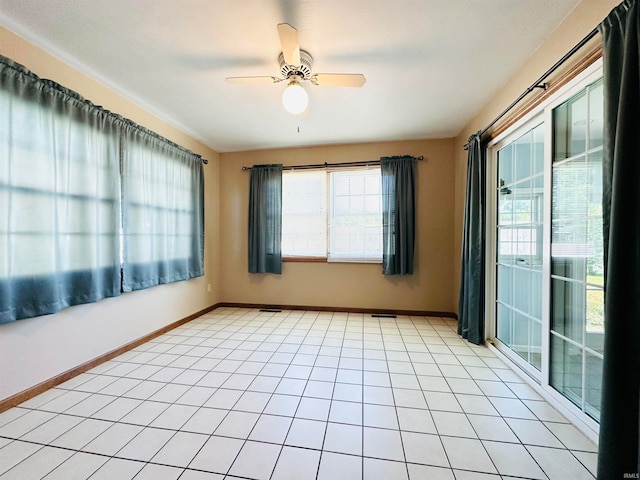 tiled empty room featuring ceiling fan