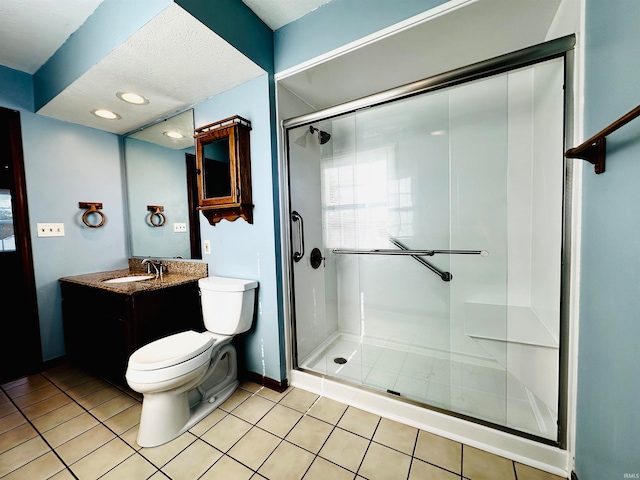 bathroom with tile patterned flooring, a shower with shower door, vanity, and toilet