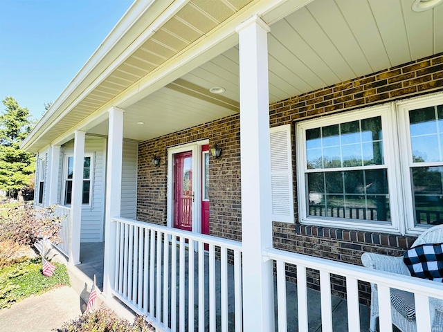 view of exterior entry featuring covered porch