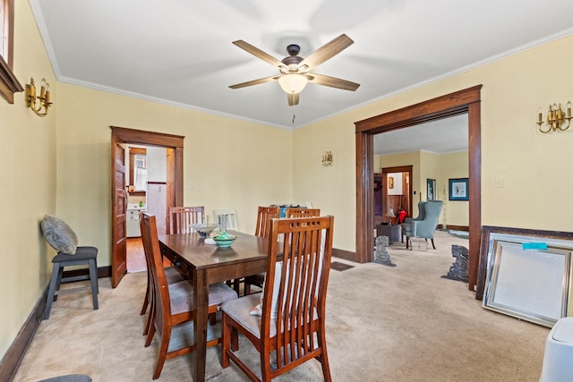 carpeted dining room featuring ceiling fan and crown molding