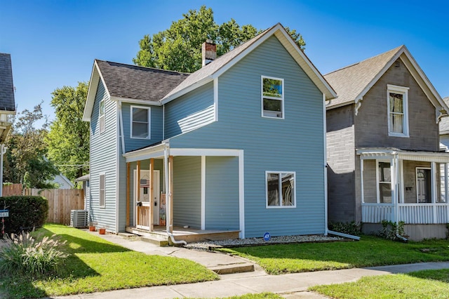 view of front of home featuring cooling unit, a front lawn, and a porch