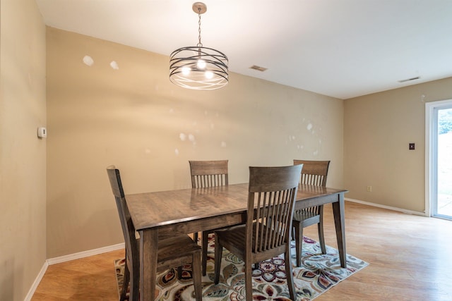 dining area featuring light hardwood / wood-style floors and a chandelier