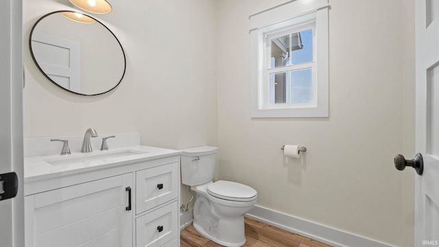 bathroom featuring vanity, hardwood / wood-style floors, and toilet