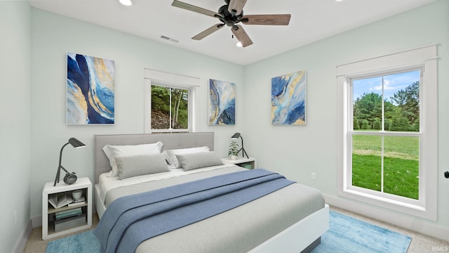 bedroom featuring multiple windows, carpet flooring, and ceiling fan