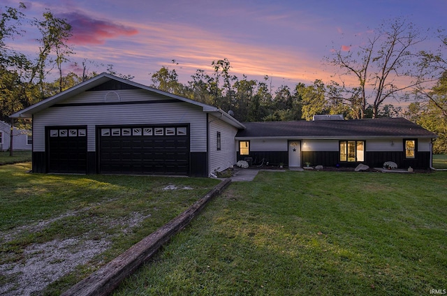 ranch-style house featuring a garage and a lawn