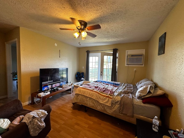 bedroom featuring ceiling fan, french doors, a textured ceiling, access to outside, and hardwood / wood-style flooring