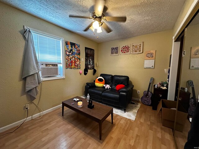 living room featuring light hardwood / wood-style flooring, cooling unit, and a textured ceiling