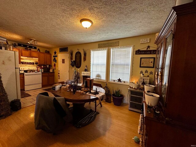 dining area with light hardwood / wood-style flooring and a textured ceiling