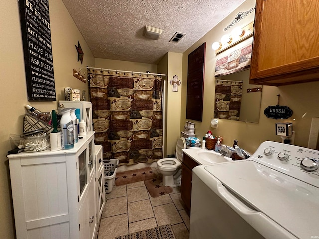 clothes washing area with washer / clothes dryer, sink, light tile patterned floors, and a textured ceiling