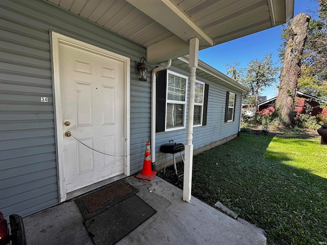 entrance to property with a lawn