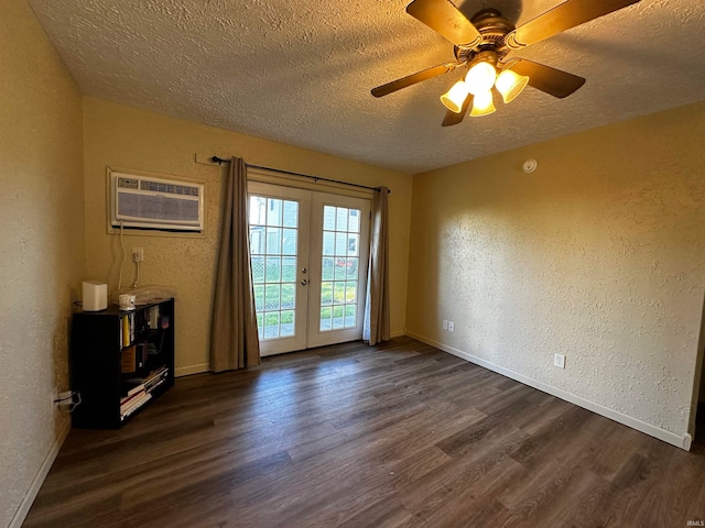 unfurnished room featuring a wall mounted air conditioner, french doors, a textured ceiling, ceiling fan, and dark hardwood / wood-style floors