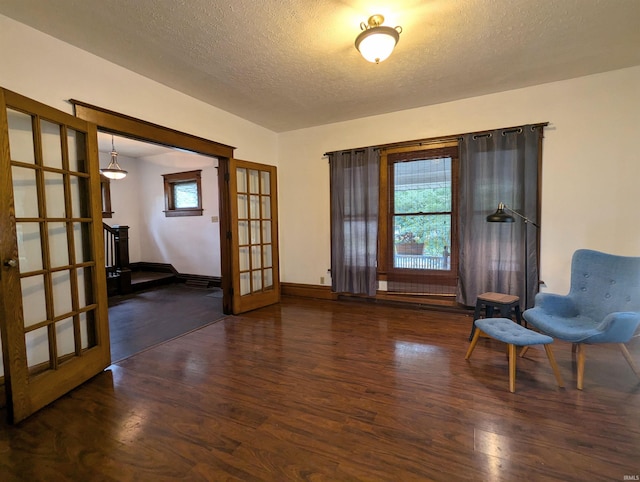 unfurnished room with a textured ceiling, dark hardwood / wood-style flooring, and a wealth of natural light