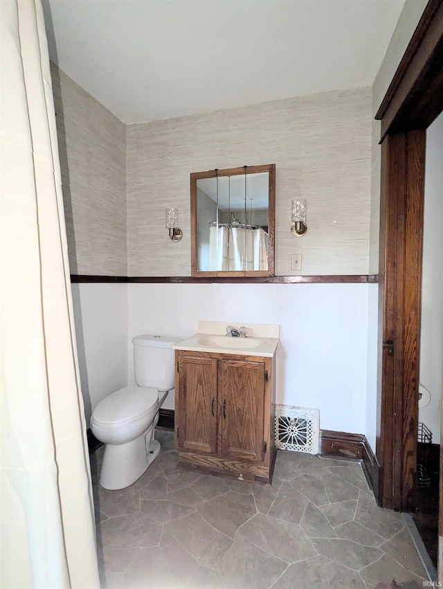 bathroom featuring vanity, tile walls, and toilet