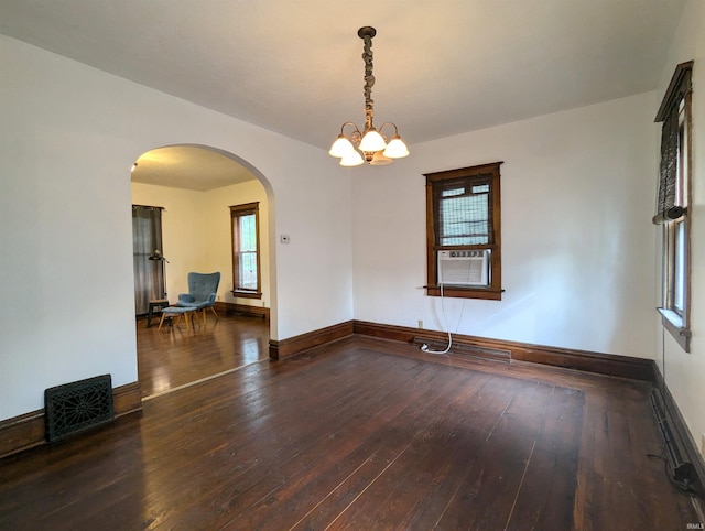 unfurnished room with an inviting chandelier, cooling unit, and dark wood-type flooring