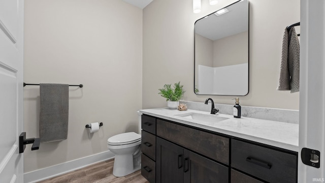 bathroom with hardwood / wood-style floors, vanity, and toilet