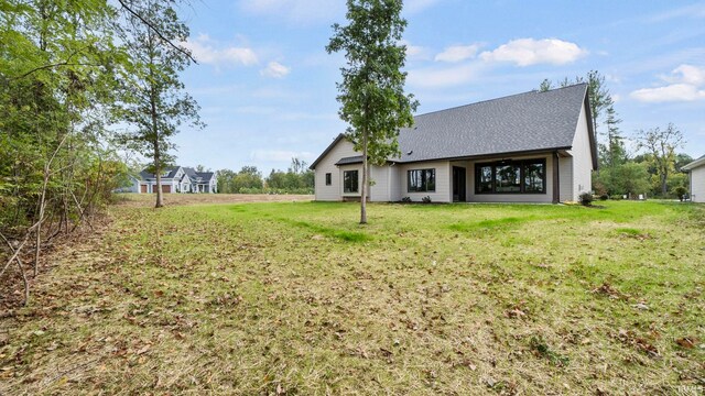 rear view of property featuring a lawn