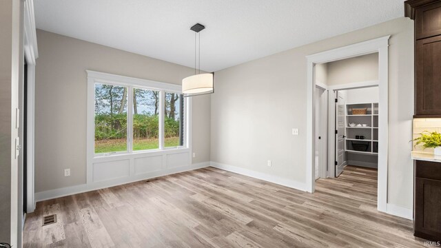 unfurnished dining area with light hardwood / wood-style floors