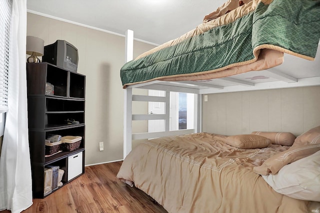 bedroom featuring hardwood / wood-style flooring and beam ceiling