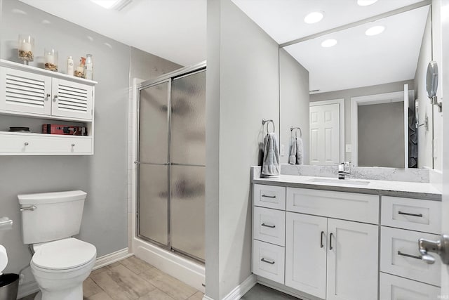 bathroom with vanity, an enclosed shower, and toilet