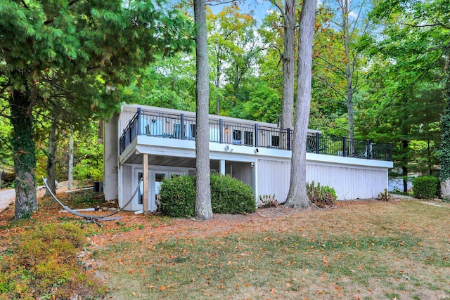 rear view of property with a lawn and a deck