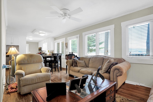 living room featuring ornamental molding, ceiling fan, and dark wood-type flooring