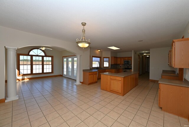 kitchen with ceiling fan, pendant lighting, light tile patterned floors, backsplash, and appliances with stainless steel finishes