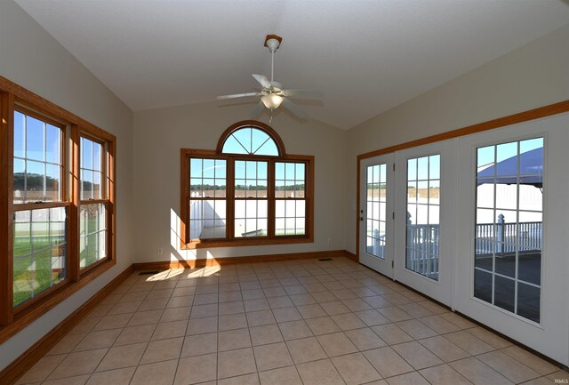 unfurnished sunroom with vaulted ceiling, ceiling fan, plenty of natural light, and french doors