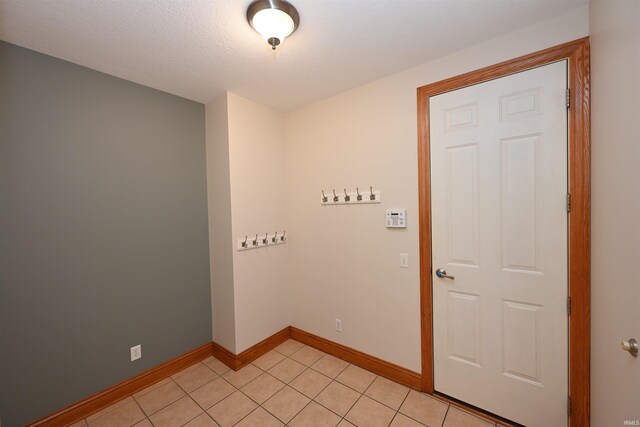 spare room featuring a textured ceiling and light tile patterned floors