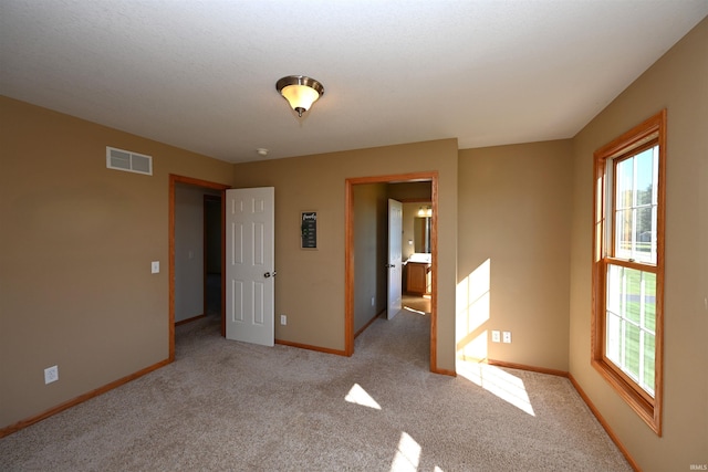 unfurnished bedroom featuring light carpet