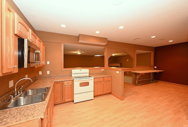 kitchen featuring light hardwood / wood-style floors, light brown cabinets, white range with electric stovetop, and sink