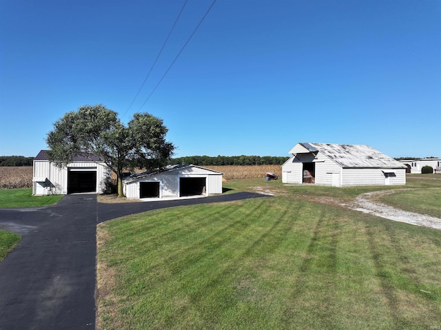 exterior space with a garage, a front yard, and an outbuilding