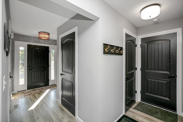 foyer with a textured ceiling and light hardwood / wood-style floors