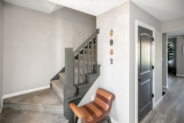 stairway featuring hardwood / wood-style flooring and a textured ceiling