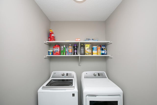 laundry area featuring a textured ceiling and washer and clothes dryer