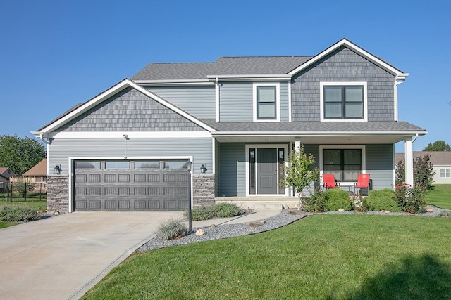 view of front facade with a front yard, a porch, and a garage