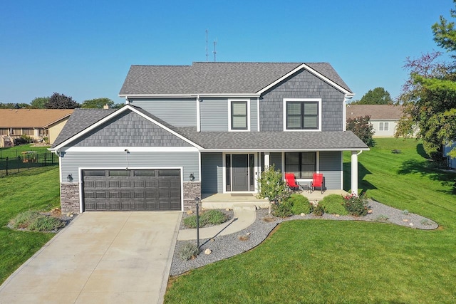 view of front of property featuring a porch, a garage, and a front lawn