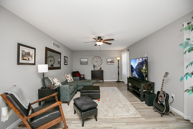 living room with light hardwood / wood-style flooring and ceiling fan