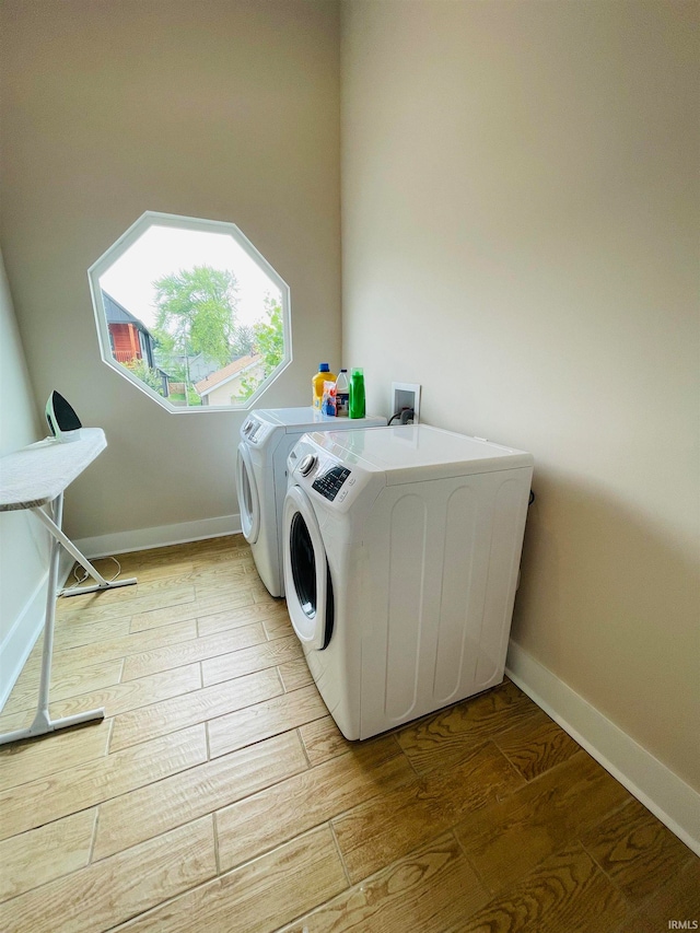 clothes washing area featuring light hardwood / wood-style floors and independent washer and dryer