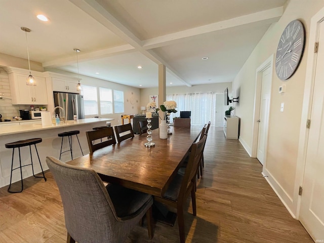 dining area featuring wood-type flooring and beam ceiling