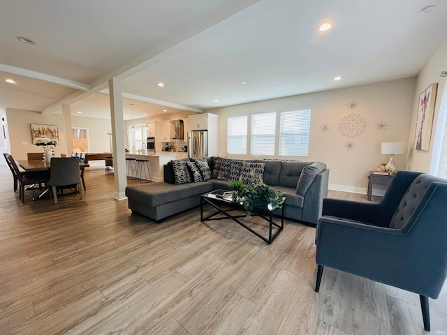 living room with light wood-type flooring and beam ceiling