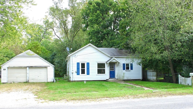 view of front facade featuring a front lawn, an outbuilding, and a garage